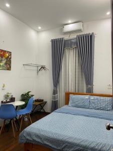 een slaapkamer met een bed en een tafel met stoelen bij An Homestay in Yen