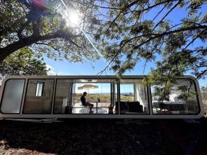 a person sitting at a table in a tiny house at Modern Off Grid Tiny Home! in Haleiwa