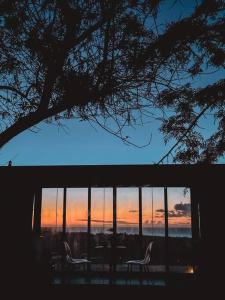 Modern Off Grid Tiny Home! في هاليوا: كرسيين يجلسون أمام النافذة عند غروب الشمس