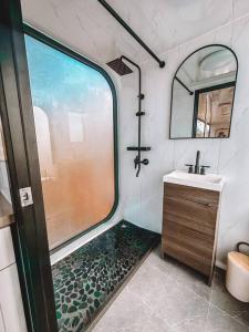 a bathroom with a shower and a sink and a mirror at Modern Off Grid Tiny Home! in Haleiwa