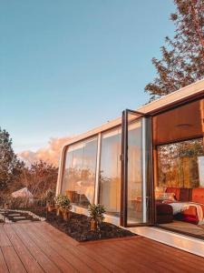 Casa con paredes de cristal y terraza de madera. en Modern Off Grid Tiny Home!, en Haleiwa