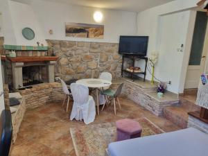 a living room with a table and a stone fireplace at Atelier apartment in Krasica