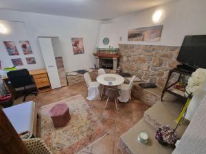 a living room with a table and a stone wall at Atelier apartment in Krasica +3 photos