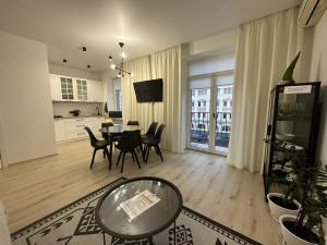 a living room with a table and chairs and a kitchen at Soborna Apartment in Rivne