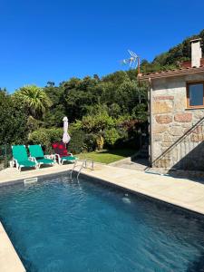 uma piscina com duas cadeiras e uma casa em Casa da Lage - Gerês - Piscina privada no Gerês