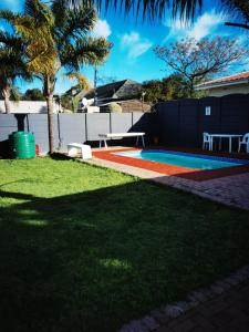 a yard with a pool with a table and a picnic table at GALAXY BOSTON BELLVILLE in Cape Town