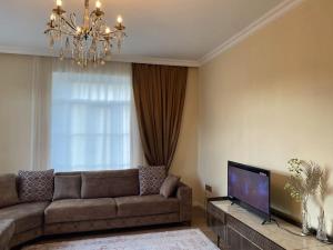 ein Wohnzimmer mit Sofa und Fernseher in der Unterkunft Barbie's house in Qax