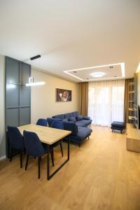 a conference room with a table and blue chairs at LA LA Marina Wave Suites in Vlorë