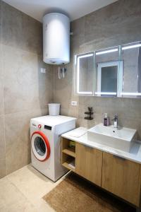a bathroom with a washing machine and a sink at LA LA Marina Wave Suites in Vlorë +29 photos