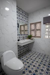 a bathroom with a toilet and blue and white tiles at Vungtau Surf Hostel in Vung Tau