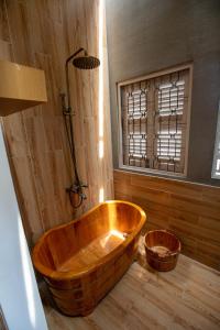 頭頓的住宿－Vungtau Surf Hostel，带窗户的浴室内的木浴缸