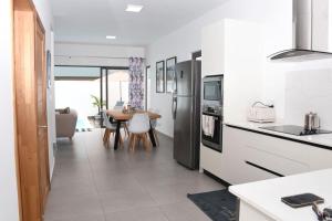 a kitchen with white appliances and a table in it at la falaise paradis Mauritius in Flic-en-Flac