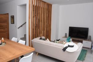 ein Wohnzimmer mit einem Sofa, einem Tisch und einem TV in der Unterkunft la falaise paradis Mauritius in Flic-en-Flac