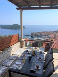 a table with plates of food on a balcony at Dalmatins MillionDollar sea view in Dubrovnik