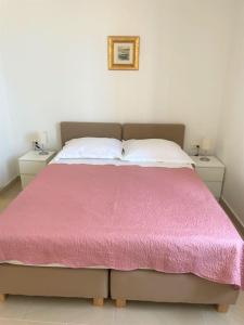 a bedroom with a pink bed with two night stands at Dalmatins MillionDollar sea view in Dubrovnik