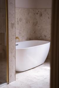 una vasca da bagno bianca seduta in bagno di Our House Collective - Luxury Stay in Lincoln City Centre, Hot tub, Sleeps 16 a Lincoln Altre 45 foto