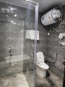 a bathroom with a toilet and a glass shower at Green valley boutique in Paro
