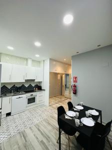- une cuisine avec une table et des chaises dans la chambre dans l'établissement HOSPEDAJE CORREDOR DE HENARES, à Torrejón de Ardoz