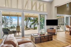 a living room with a couch and a tv at Oceans Edge Beach House At Oak Beach in Oak Beach