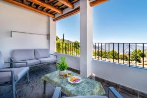 um pátio com uma mesa e cadeiras e uma varanda em Casa Jose Capileira - Alpujarra em Capileira