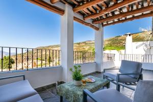 a patio with chairs and a table with a view at Casa Jose Capileira - Alpujarra in Capileira