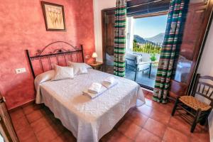 a bedroom with a bed and a window with a view at Casa Jose Capileira - Alpujarra in Capileira