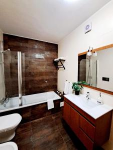 y baño con bañera, aseo y lavamanos. en Apartamento Vila Rosa - PRAIA DA ROCHA, en Portimão