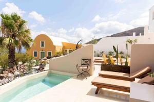 a villa with a swimming pool and a house at Pink Freud Villas Santorini in Oia