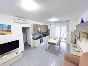 un salon avec une table et une cuisine dans l'établissement Appartamento Palazzo Moretto, à Chioggia