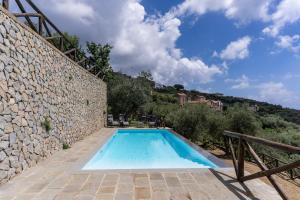 an outdoor swimming pool in a stone wall with a blue at Giuliana in Massa Lubrense