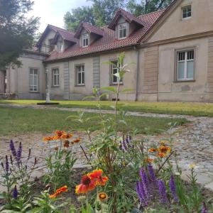 a garden in front of a house with flowers at Dworek Cieszków in Cieszków