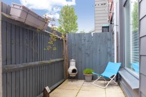 a patio with a blue chair and a fence at Bright Groundfloor 3BR Flat, Brockley, SE London in London