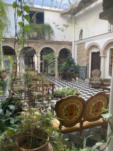 a courtyard with chairs and plants in a building at Hostal Palacio del Corregidor in Córdoba