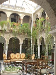 a patio with tables and chairs in a building at Hostal Palacio del Corregidor in Córdoba