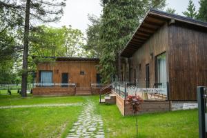 una cabaña de madera con una pasarela delante de ella en Pension Andra's House, en Horezu