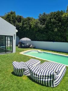 tre ombrelloni seduti sull'erba vicino a una piscina di Holiday home in Fresnay-NO load shedding in a secure estate a Città del Capo