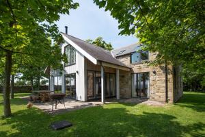 an exterior view of a stone house with a patio at Vesta View in Hexham