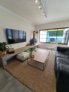 un soggiorno con divano e tavolo di Holiday home in Fresnay-NO load shedding in a secure estate a Città del Capo