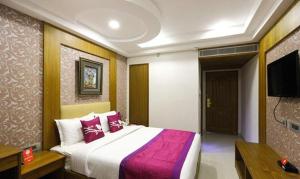 um quarto com uma cama grande e uma televisão de ecrã plano em FabHotel Prime The Vijay Park em Chennai