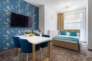 pokój hotelowy z łóżkiem, stołem i krzesłami w obiekcie Gotyk w Toruniu