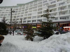 a pile of snow in front of a large building at Precioso Apartamento en la plaza in Sierra Nevada