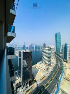 Studio with burj view at Elite Business bay Residence by ANW vacation homes في دبي: اطلالة على مدينة بها نهر ومباني