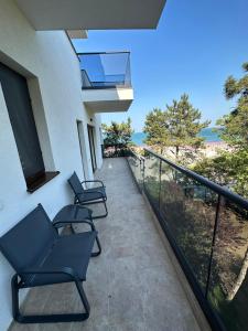 Un balcón con sillas y vistas al océano. en FORREST Villa, en Eforie Nord