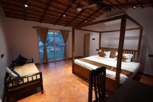 Schlafzimmer mit Himmelbett und Fenster in der Unterkunft RUSTIC VOGUE in Shamirpet