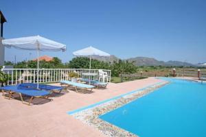 ein Pool mit zwei Tischen und Sonnenschirmen neben in der Unterkunft Villa Eleana in Chania