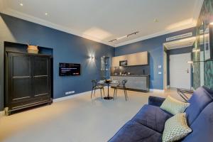 sala de estar con paredes azules y sofá en Boutique Central Apartments- Happy Rentals, en San Remo