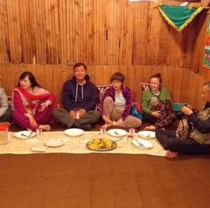un grupo de personas sentadas alrededor de una mesa en Island, en Srinagar