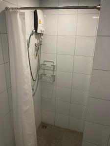 a shower with a shower curtain in a bathroom at Stay Wanglang in Bangkok