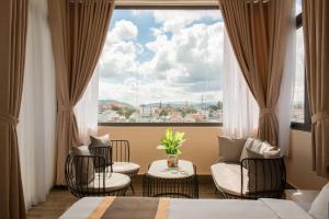 ein Hotelzimmer mit einem großen Fenster mit Stühlen und einem Tisch in der Unterkunft BẢO DUY HOTEL 5 in Da Lat