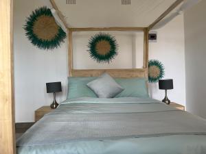 a bedroom with a bed with green wreaths on the wall at Ndau Lodge in Nkhata Bay